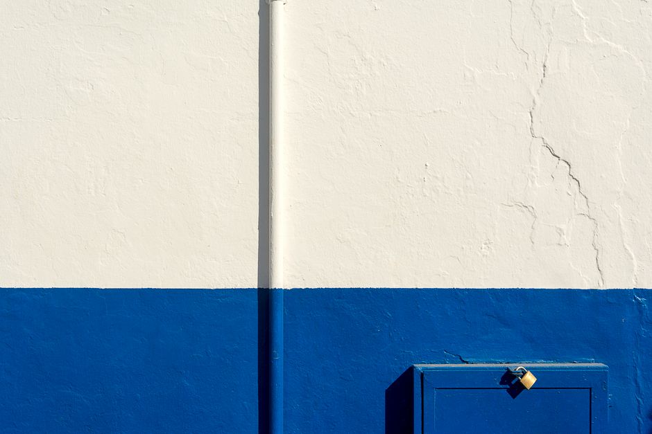 Exterior wall and trim of a painted home under a clear sky