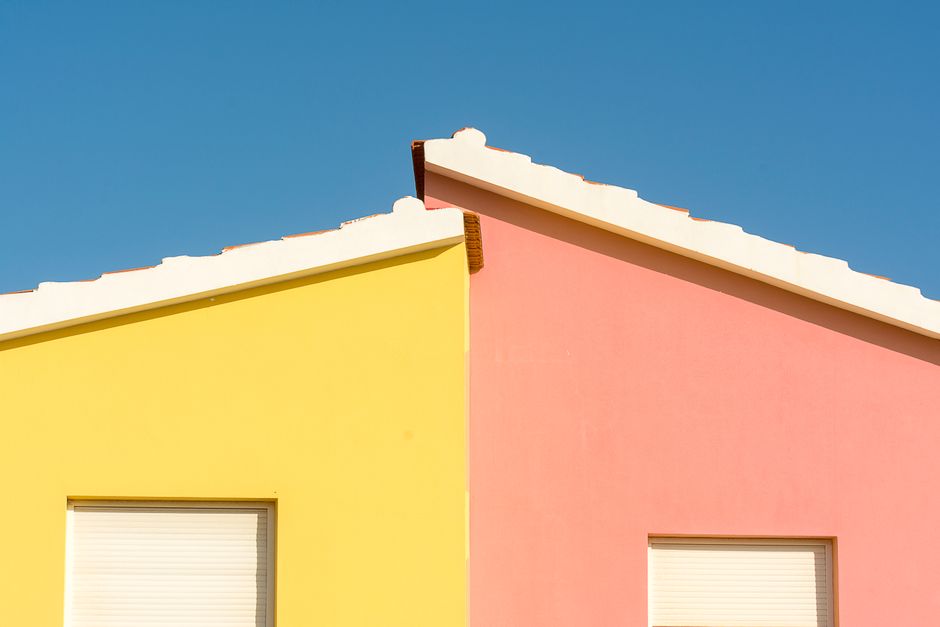 Exterior wall and trim of a painted home under a clear sky